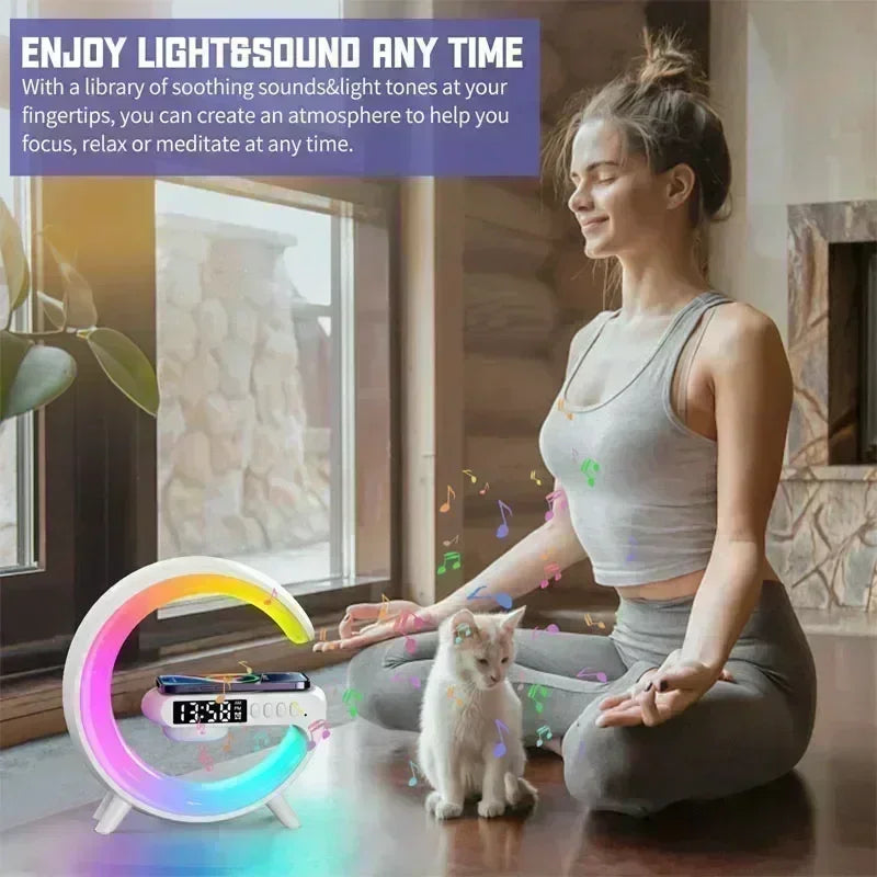 Woman meditating next to an RGB wireless charging station with speaker and a small white cat indoors